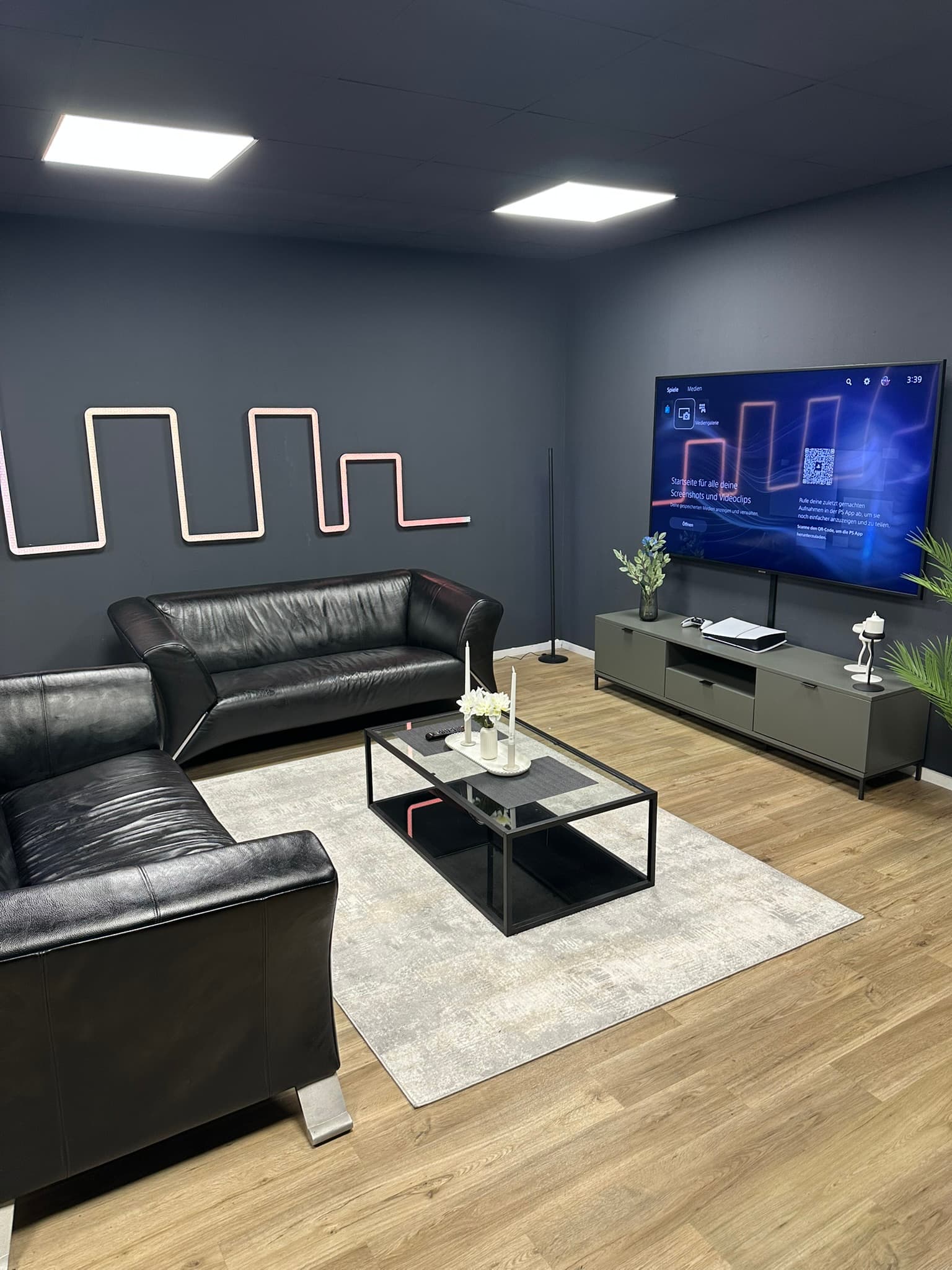 Lounge mit Ledercouch und PS5 im Gaming Loft